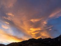 Verzerrte Föhnwolken leuchten am Morgenhimmel über der Kampenwand